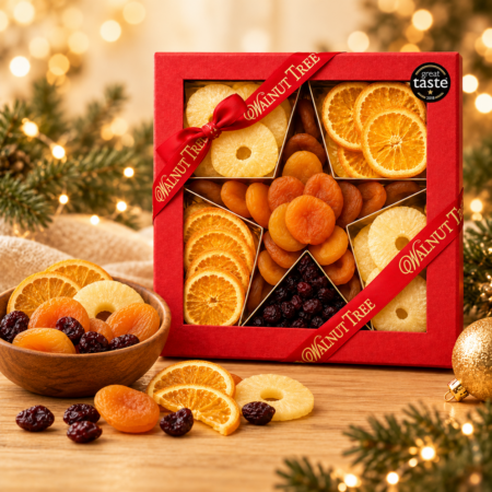 Walnut Tree luxury dried fruits Christmas gift box featuring apricots, orange slices, pineapple rings and dark dried berries, presented in a red gift box with gold ribbon, wooden bowl and warm festive lights.