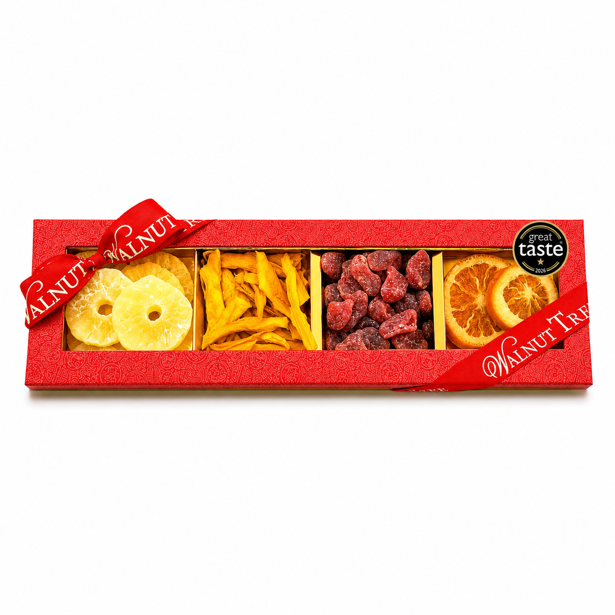 Walnut Tree luxury four-compartment dried fruit gift box featuring pineapple rings, dried mango strips, red dried fruits and orange slices, presented in red packaging with gold ribbon and Great Taste award badge against a warm festive Christmas background.