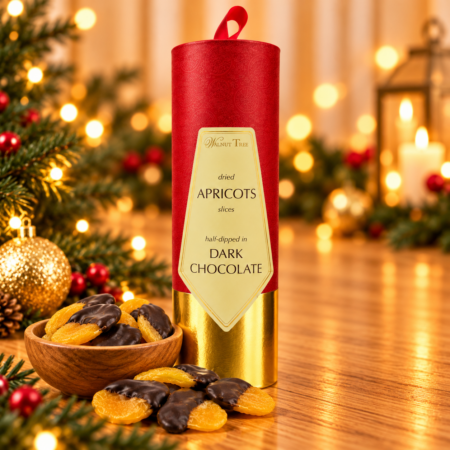 Walnut Tree luxury Christmas gift scroll containing dried apricot slices half-dipped in dark chocolate, presented in red and gold packaging with a wooden bowl of chocolate apricots, festive greenery and warm golden Christmas lights.