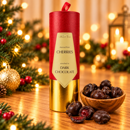Walnut Tree red and gold Christmas gift scroll of maraschino cherries enrobed in dark chocolate, displayed with a wooden bowl of chocolate cherries, golden Christmas lights and festive greenery.