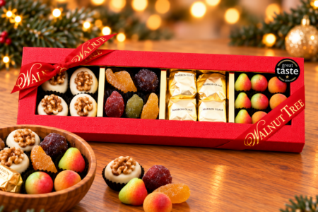 Walnut Tree luxury long four-compartment confectionery gift box featuring walnut-topped marzipan, glacé fruits, marrons glacés and colourful marzipan fruits, presented with a wooden bowl, red and gold ribbon and Great Taste award badge in a festive Christmas setting.