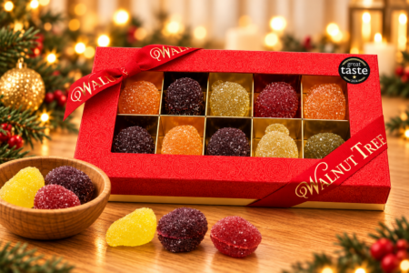 Walnut Tree luxury medium gift box containing ten assorted sugar-coated fruit-shaped jellies, presented in red and gold packaging with a Great Taste award badge, wooden bowl and warm Christmas lights.