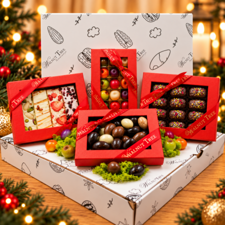 Walnut Tree festive confectionery gift set with four red gift boxes displayed on branded white presentation boxes against a warm Christmas background