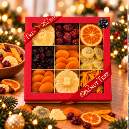 Walnut Tree luxury nine-compartment dried fruit gift box featuring assorted dried and glacé fruits, presented in red packaging with gold ribbon and Great Taste award badge against a warm Christmas background.