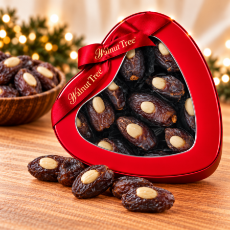 Walnut Tree almond-stuffed dates in a red heart-shaped gift tin with branded ribbon, surrounded by premium dates in a festive Christmas setting.