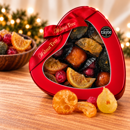 Walnut Tree luxury glacé fruits in a red heart-shaped gift tin with branded ribbon and Great Taste award, featuring colourful candied citrus and cherries in a festive Christmas setting.
